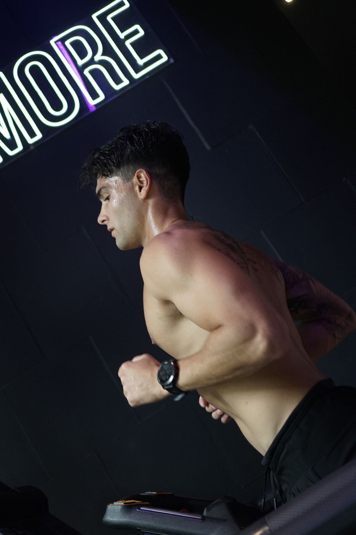 Member sprinting under the MORE neon sign